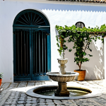 A Tranquil Portuguese Courtyard**

A serene inner courtyard in Portugal, sunlit, with whitewashed walls and traditional azulejo tiles. Potted plants and climbing vines adorn the walls. A small stone fountain trickles gently. Safe for work, appropriate content, fully clothed, family-friendly. Perfect anatomy, correct proportions, natural pose. High quality, professional photography, natural lighting, detailed textures.

**